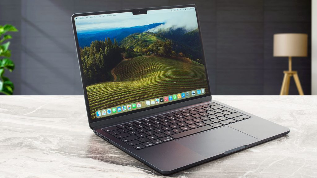 Midnight dark grey Apple MacBook Air 13 laptop open on a table showing wallpaper