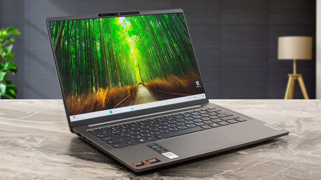 Grey Lenovo IdeaPad Pro 5 laptop open on a table showing a bright green background wallpaper