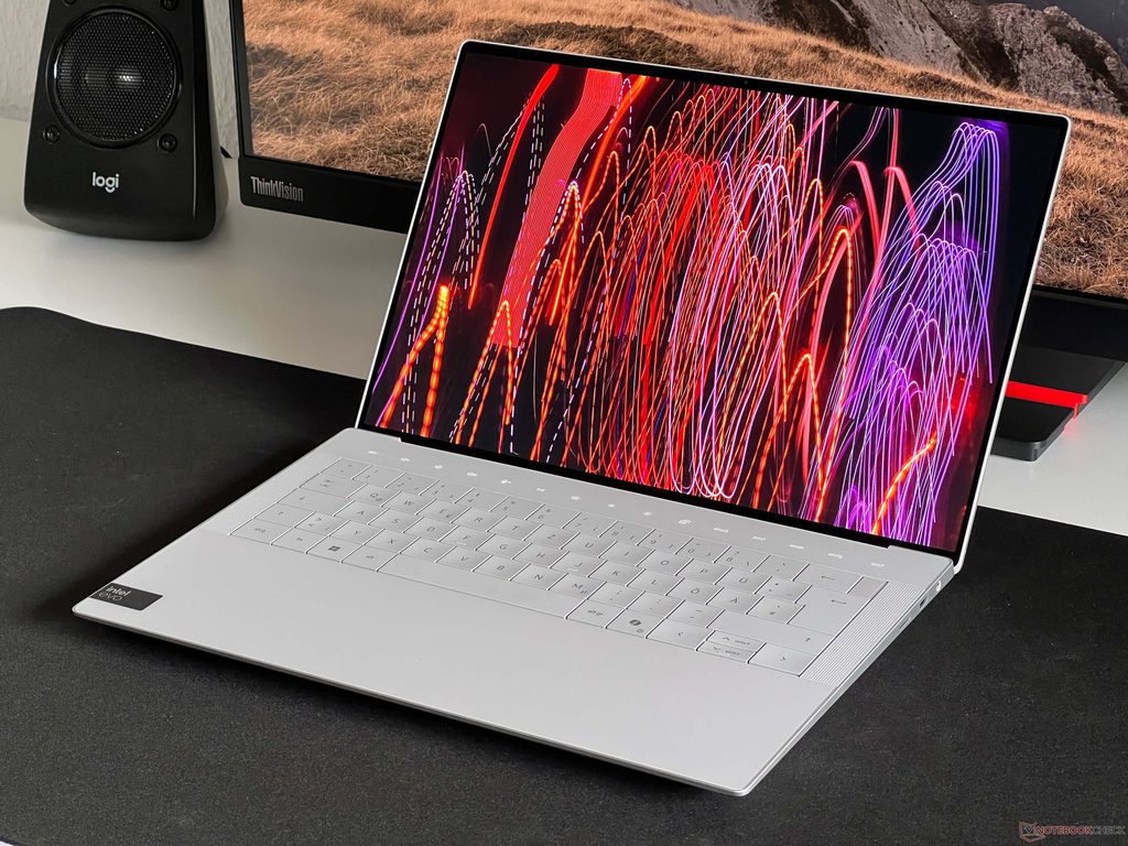 Silver Dell XPS 14 laptop open on a black surface showing vibrant colorful wallpaper