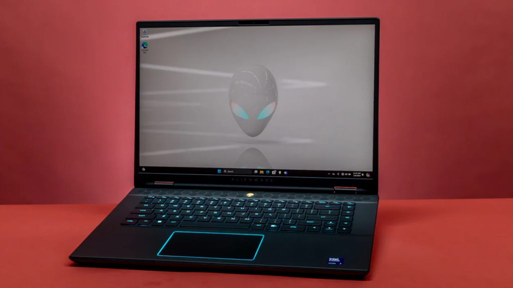 Black Dell Alienware m16 gaming laptop open on a surface with blue backlit keyboard and touchpad