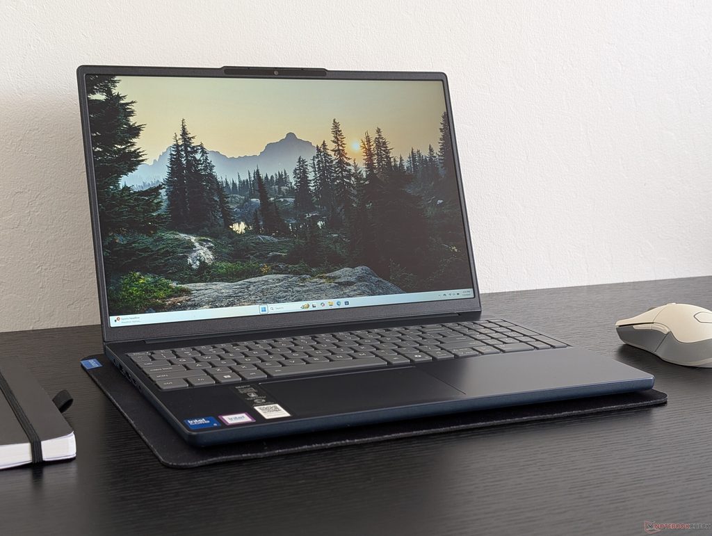 Dark grey Lenovo IdeaPad Slim 3 laptop open on a desk next to a mouse