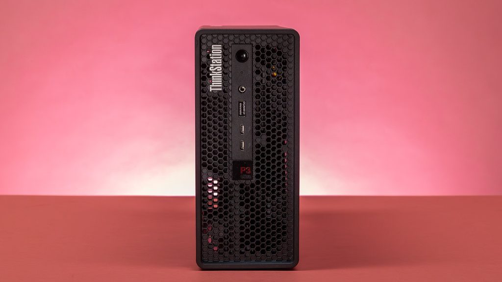 Black Lenovo ThinkStation P3 workstation desktop sitting on a table showing front mesh design